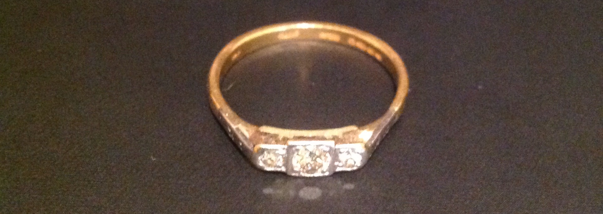 A HALLMARKED 22CT GOLD AND DIAMOND THREE STONE RING The central brilliant cut diamond, with a