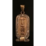 A FOREIGN TWO COLOUR GOLD PENDANT In the form of an Ancient Egyptian cartouche, with hieroglyphic