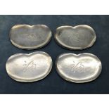 A SET OF FOUR 20TH CENTURY JAPANESE SILVER DISHES In the form of lotus leaves, bearing script to