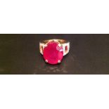 A HALLMARKED 18CT GOLD, RUBY AND DIAMOND DRESS RING The large oval cut ruby claw set, above square