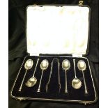 A SET OF SIX SILVER TEASPOONS AND A PAIR OF SUGAR TONGS Having seal top designs, contained in