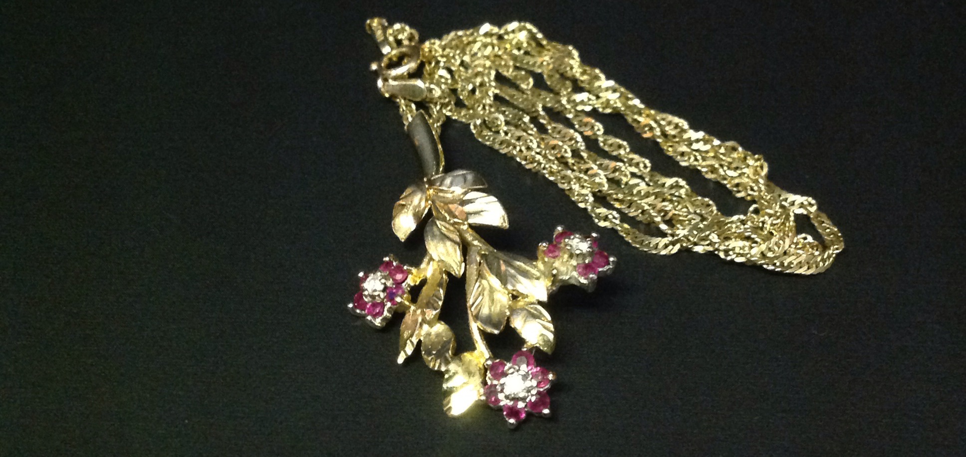 A 9CT GOLD, RUBY AND DIAMOND SET PENDANT  In the form of a flowering branch, having three