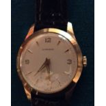 GARRARDS, A 9CT GOLD GENTLEMEN'S WRISTWATCH Having a circular silver tone dial, with gilt number