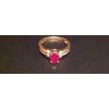 A HALLMARKED 18CT GOLD, RUBY AND DIAMOND RING The central claw set oval cut ruby, with seven small