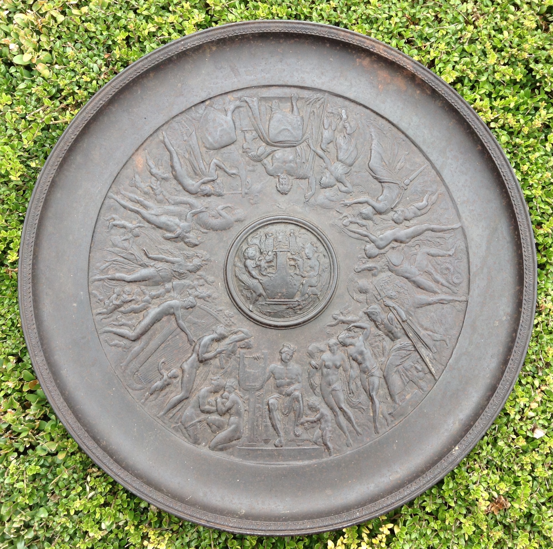 A 19TH CENTURY FRENCH CAST IRON CHARGER With Neoclassical embossed design of musicians, gladiators