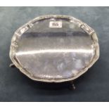 AN ENGLISH HALLMARKED SILVER CARD TRAY With a piecrust border, raised on four legs with hoof