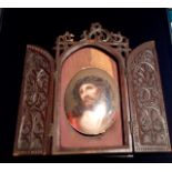 A 19TH CENTURY CONTINENTAL OVAL PORCELAIN PLAQUE  Portrait of Christ, held in a finely carved oak