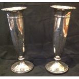 A PAIR OF EARLY 20TH CENTURY SILVER VASES Having a faceted design to body and a scalloped edge,