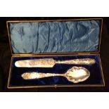 A PAIR OF LATE 19TH/EARLY 20TH CENTURY WHITE METAL SERVING SPOONS Cast with stylized flora and fauna