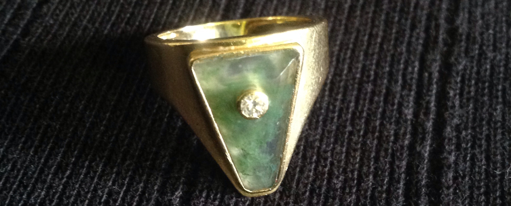 AN UNUSUAL AND STYLISH 18CT GOLD, MOSS AGATE AND DIAMOND RING  The wide gold shank enclosing a