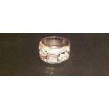 AN 18CT WHITE GOLD AND DIAMOND DRESS RING The wide band set with a central panel of four Princess