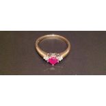 A HALLMARKED 9CT GOLD, RUBY AND DIAMOND RING The central heart shaped ruby of good colour claw set