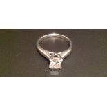 AN 18CT WHITE GOLD PRINCESS CUT DIAMOND SOLITAIRE RING The diamond claw set and flanked by solid