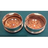 A PAIR OF HALLMARKED SILVER AND ROSEWOOD WINE COASTERS Decorated with a stepped design and raised on