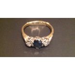 AN 18CT GOLD AND PLATINUM SET SAPPHIRE AND DIAMOND THREE STONE RING The central oval cut claw set