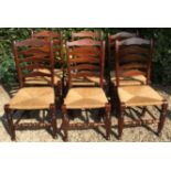 A SET OF SIX 19TH CENTURY OAK LADDER BACK CHAIRS With rush seats.