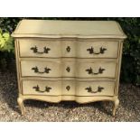 AN EARLY 20TH CENTURY CONTINENTAL CREAM AND PARCEL GILT PAINTED COMMODE Of serpentine style, with an