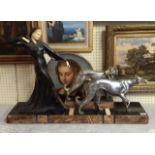 AN ART DECO PERIOD BRONZE AND IVORINE STATUE A lady with lurchers, raised on a marble base. (79cm