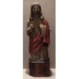 A 19TH CENTURY POLYCHROME WOOD CARVING OF CHRIST Wearing white and red robes, with right hand