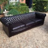 A LARGE VICTORIAN DESIGN BLACK LEATHER BUTTON BACK THREE SEATER SETTEE. (w 236cm x d 84cm)