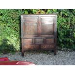 AN 18TH CENTURY OAK LIVERY CUPBOARD With two large panelled doors, over two long drawers, raised