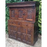 AN 18TH CENTURY AND LATER OAK COURT CUPBOARD With an arrangement of carved ogee panelled doors and