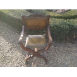 AN EARLY 20TH CENTURY MAHOGANY AND GREEN LEATHER UPHOLSTERED THRONE ARMCHAIR  The back rail carved