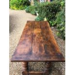 A 17TH CENTURY DESIGN OAK TABLE With a three plank top, raised on heavy turned square legs, joined