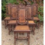 A SET OF SIX VICTORIAN OAK DINING CHAIRS Heavily carved with leaves and berries, having caned