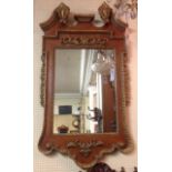 A 19TH CENTURY WALNUT AND PARCEL GILT FRAMED MIRROR With swan neck pediment, above a silvered plate.