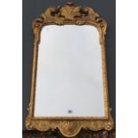 A GEORGE I DESIGN GILT FRAMED MIRROR Crested with a fleur de lis, above a shaped bevelled plate. (