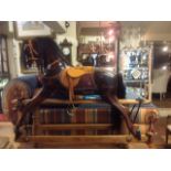 AN EDWARDIAN PINE ROCKING HORSE With a tan leather saddle and real hair mane.  (120cm x 104cm)