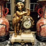 A LATE 19TH CENTURY FRENCH FIGURAL TABLE/MANTLE CLOCK With a statue of a putti leaning against a