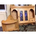 A PINE WALL-HANGING CUPBOARD With etched blue glass doors, open shelves and drawers, along with a