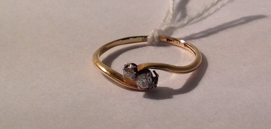 AN 18CT GOLD AND DIAMOND THREE STONE RING  The round brilliant cut diamonds graduated and set within