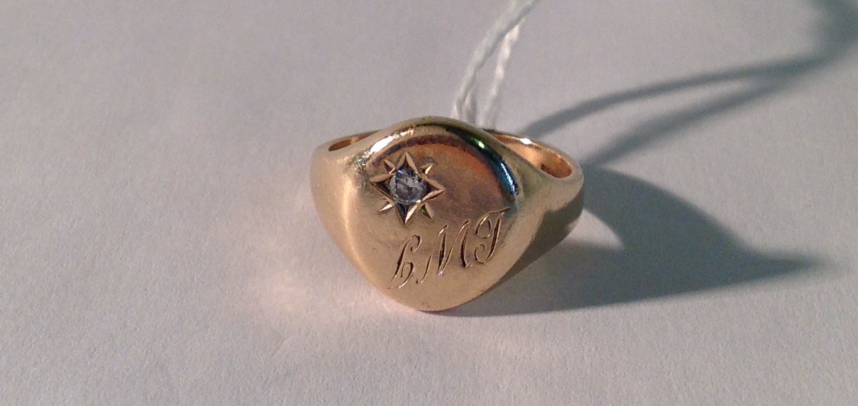 AN EARLY 20TH CENTURY 9CT GOLD AND DIAMOND STUDDED SIGNET RING Engraved with the initials 'L.M.