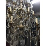 AN IMPRESSIVE FRENCH GILT METAL AND GLASS CHANDELIER With eighteen branches and twelve lights.