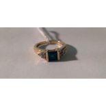 A 9CT GOLD, PASTE AND DIAMOND RING The square step cut faux emerald channel set, between yellow gold