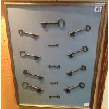 A FRAMED AND GLAZED COLLECTION OF THIRTEEN ANTIQUE KEYS. (48cm x 63cm)