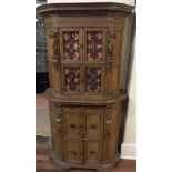 AN ANTIQUE FLEMISH OAK SIDE CABINET  The arched frieze above wrougt iron panelled doors and enclosed