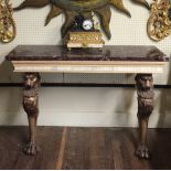 A REGENCY DESIGN CONSOLE TABLE With a rouge marble top, on lion column supports.