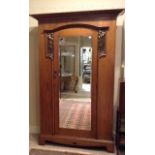 ARTS & CRAFTS, A 19TH CENTURY OAK SINGLE WARDROBE Having a mirrored door flanked by two copper