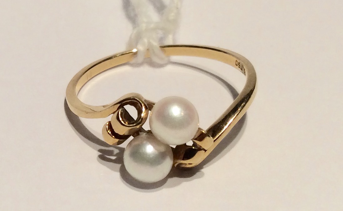 A MIKIMOTO 18CT GOLD AND CULTURED PEARL DRESS RING Set with two 4mm cultured pearls peg set to a