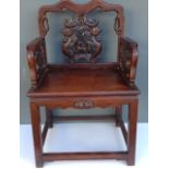 AN EARLY 20TH CENTURY CHINESE PADOUK OPEN ARMCHAIR With a heavily carved back and solid seat, raised