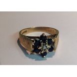 A VINTAGE HALLMARKED 9CT GOLD, SAPPHIRE AND DIAMOND FLOWERHEAD CLUSTER/DRESS RING The single diamond