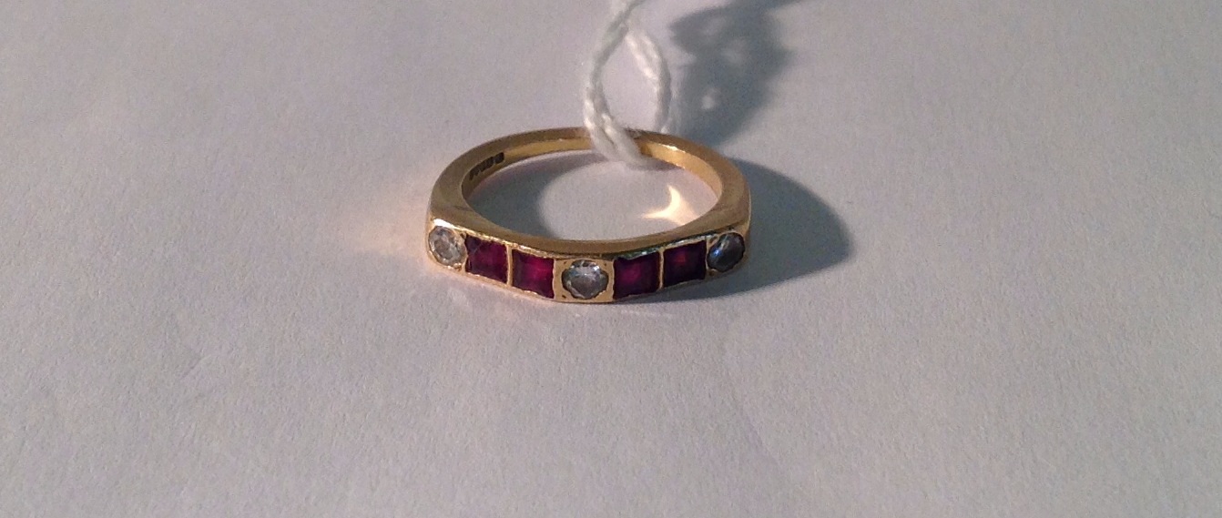 AN 18CT GOLD, DIAMOND AND RUBY RING The three round brilliant cut diamonds divided by two pairs of