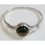 A Norwegian modernist silver tiger's eye bangle, c.1970, by A Holthe of Arandel, a circular cabochon