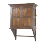 A walnut wall cabinet, in the style of E W Godwin, late 19th century, with panelled doors and sides,