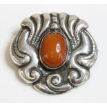 A Skonvirke Danish brooch, c.1910, with an oval cabochon amber rub set to the centre, with a