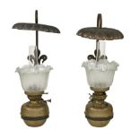A pair of Arts and Crafts wrought iron, brass and copper oil lamps, with etched shades, a sinuous
